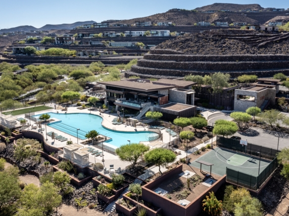 Aerial view of Ascaya in Henderson, Nevada, showcasing the private clubhouse, resort-style pool, fitness amenities, custom luxury homes, and terraced mountainside setting overlooking the Las Vegas Valley.