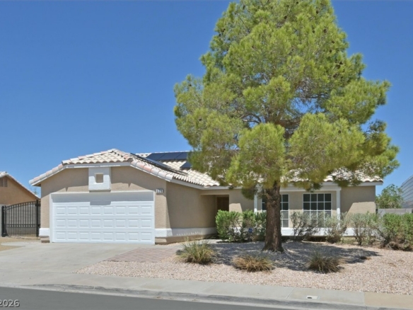 Single-family home without an HOA in Henderson, Nevada, featuring a single-story design, desert landscaping, solar panels, and gated side access.