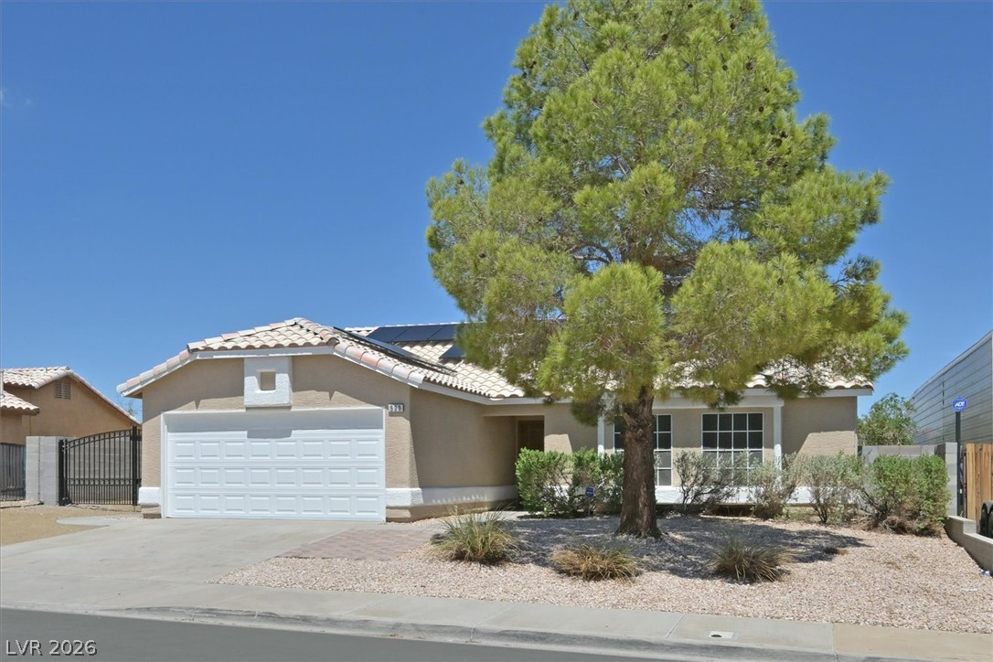 Single-family home without an HOA in Henderson, Nevada, featuring a single-story design, desert landscaping, solar panels, and gated side access.